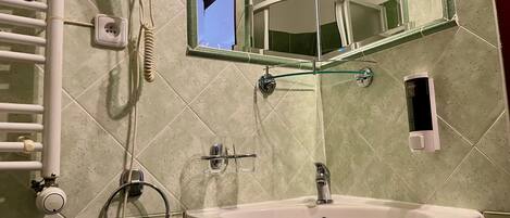 A bathroom with a sink, mirror, towel rack, and a hairdryer.