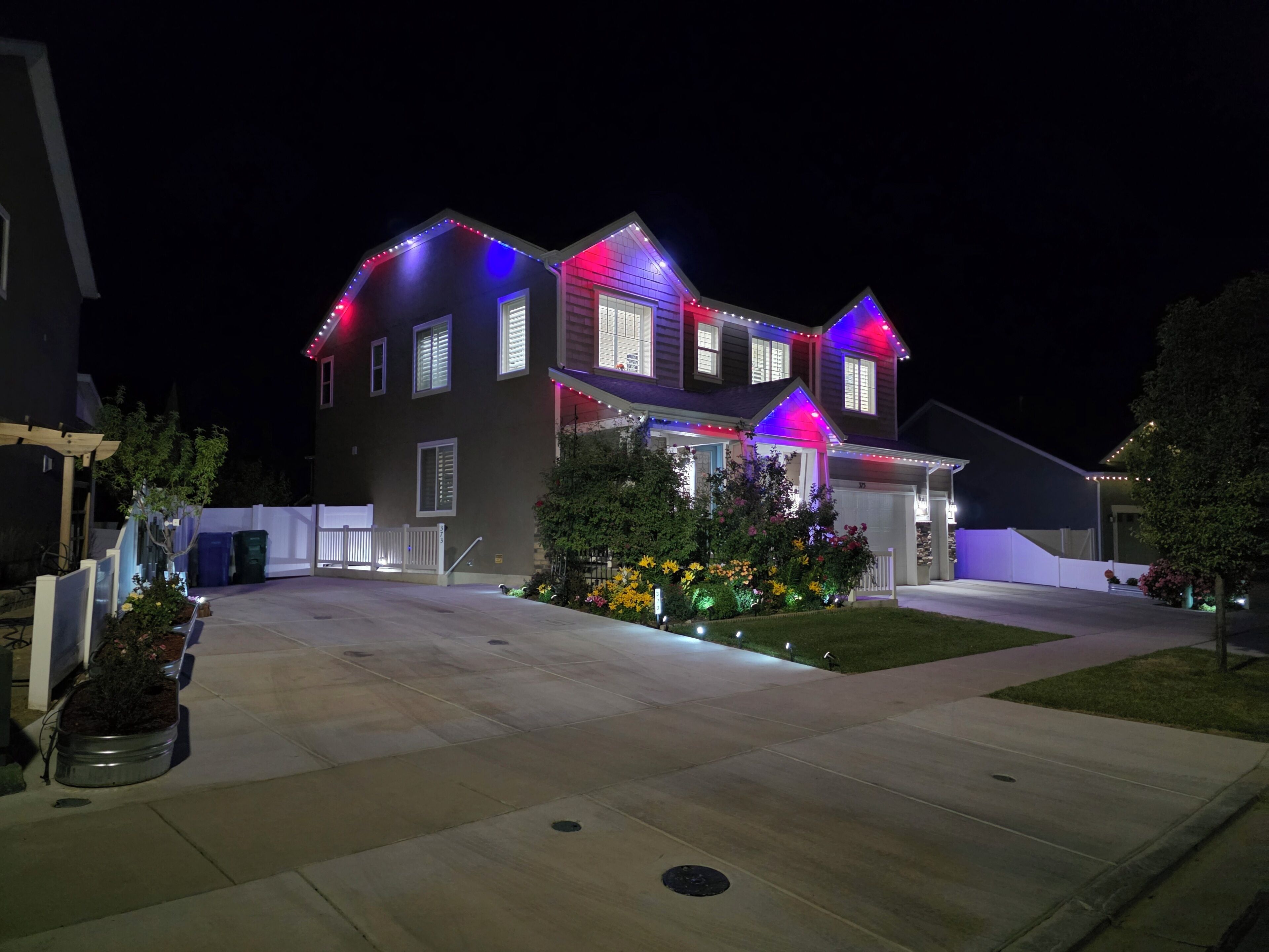 Red, white & blue LED lights outline this modern home at night – perfect for Jul