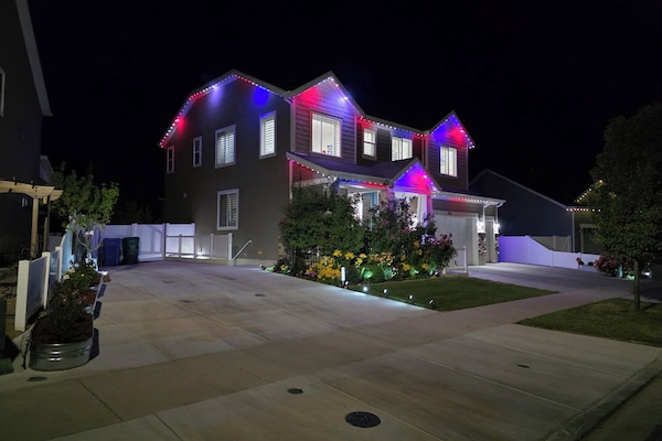 Red, white & blue LED lights outline this modern home at night – perfect for Jul