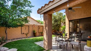 A patio with outdoor furniture, a ceiling fan, and a small table with a potted plant. - Cool & Comfy Tucson Summer Retreat w/ Yard (Tucson)