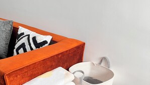 A wooden bedside table with a drawer, a white woven basket, and a folded white towel. - Scenic Studio Escape with Parking in Kiambu Rd (Kiambu)