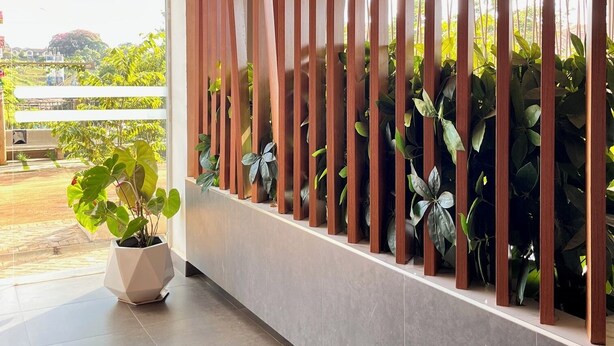 A modern interior with a glass partition, potted plants, and a view of greenery outside. - Scenic Studio Escape with Parking in Kiambu Rd (Kiambu)