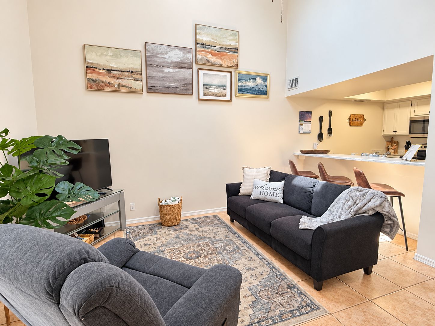 A modern living room with a sofa, a TV, and artwork on the wall.