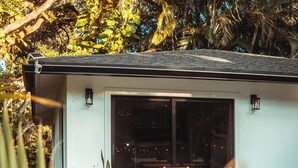 Une maison moderne dotée d’un patio aménagé avec des meubles en bois et des plantes en pot.