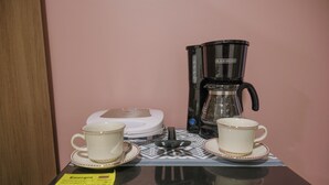 A table with two white cups and saucers, a coffee maker, and a scale. - Davé Paradise (Cartagena)