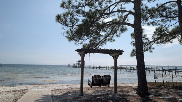 Ein Strand mit einer Holzwentil und einer Pergola.