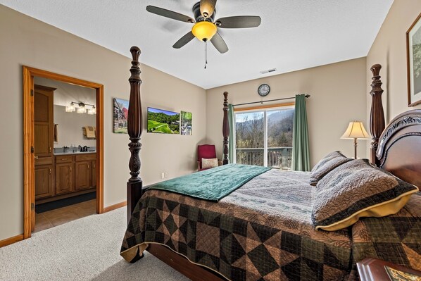 A bedroom with a bed, a ceiling fan, a window with curtains, a clock, and a door leading to another room. - Fairway & Mountain Views, Relaxing 2BR Condo Retreat (Whittier)