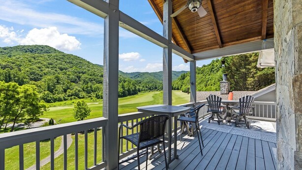 A covered outdoor area with a table and chairs, overlooking a golf course. - Fairway & Mountain Views, Relaxing 2BR Condo Retreat (Whittier)