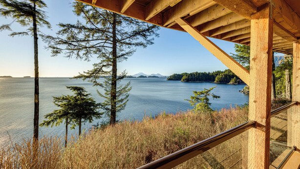 A wooden structure with a view of a calm lake and distant mountains. - Hot Tub & Whale Watching! Scenic Sitka Escape (Sitka)