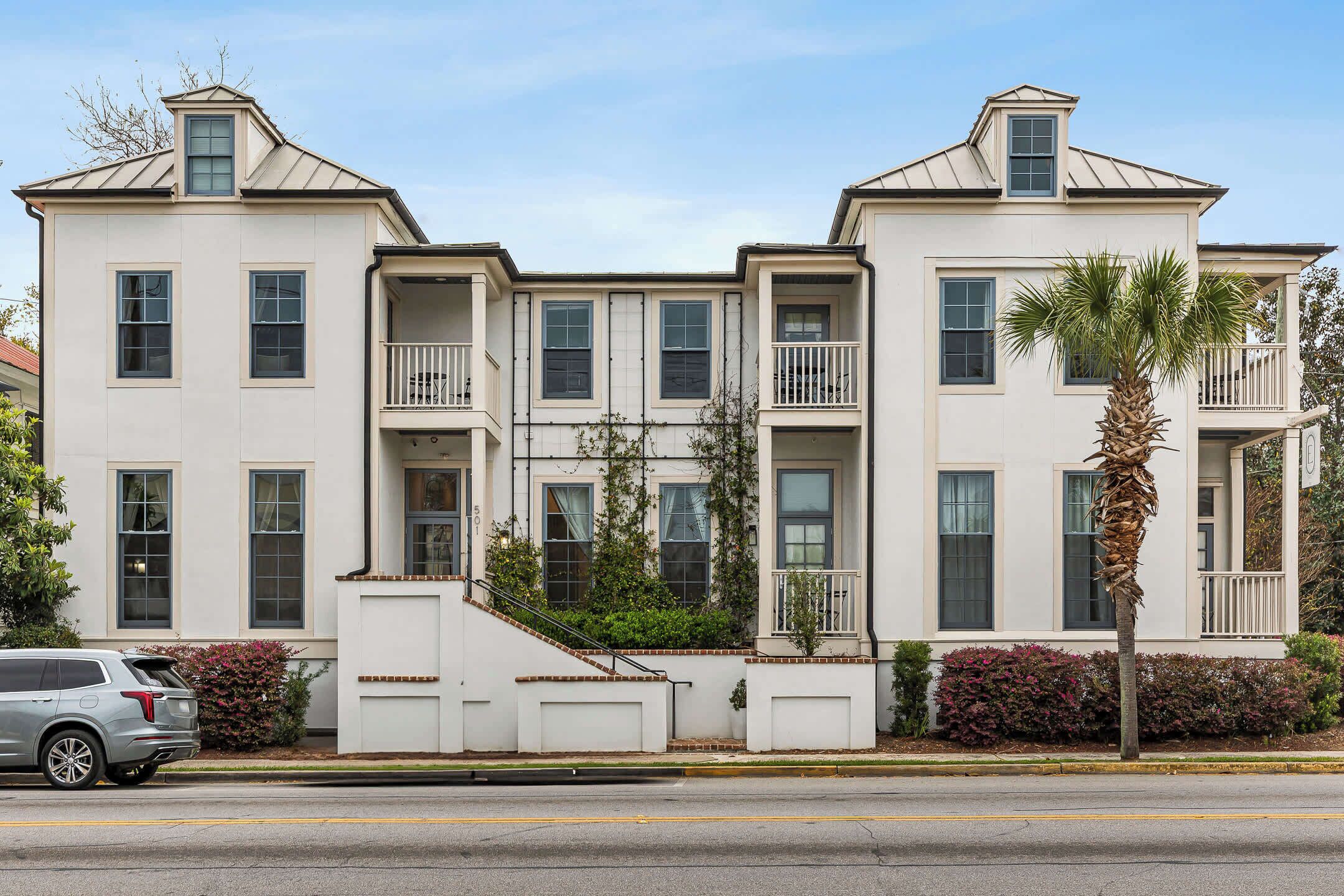A two-story building with a symmetrical facade, multiple windows, and balconies.