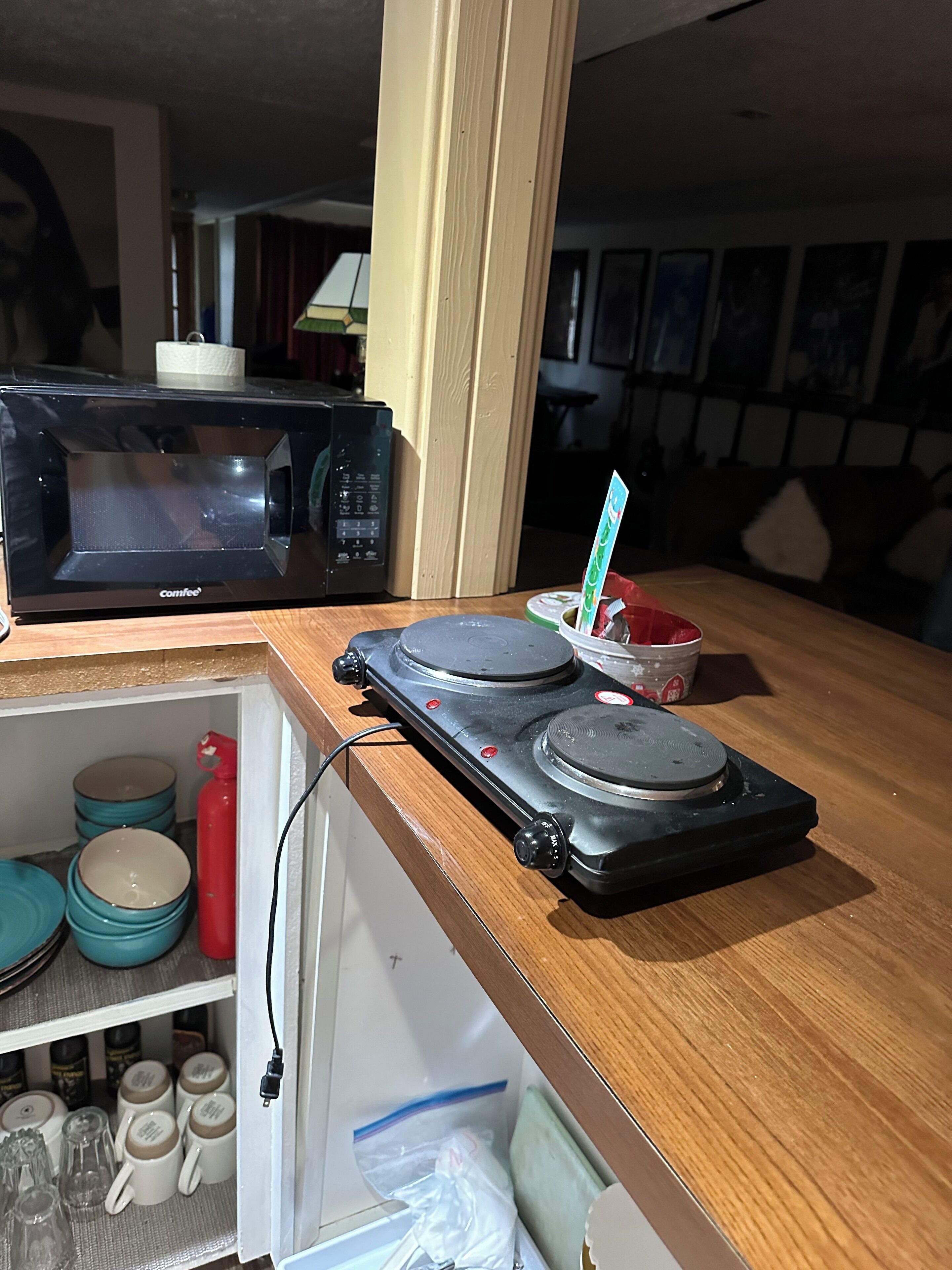 A kitchen with a microwave, a coffee machine, and a small refrigerator.