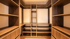 A walk-in closet with multiple wooden shelves and a central ladder. - Stunning Condo at The Pearl in Jaco Beach 6B (Jacó)