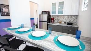 A modern kitchen with white cabinets, a stainless steel refrigerator, and a tiled backsplash. - Modern Retreat By The Beach (San Juan)