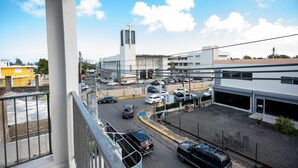 A view of a parking lot with multiple cars, a building with a cross on top, and a clear blue sky. - Modern Retreat By The Beach (San Juan)