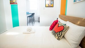 A hotel room with a bed, a desk, and chairs. - Modern Retreat By The Beach (San Juan)
