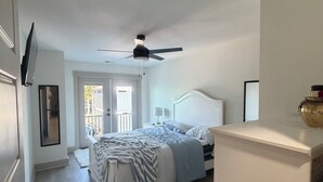A bedroom with a bed, bedside table, and a ceiling fan. - Spacious 6-bedroom house in wonderful Ocean Lakes (Myrtle Beach)