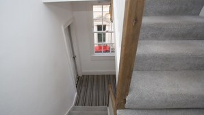 Eine Treppe mit einem Holzgeländer und einer Teppichstufe.