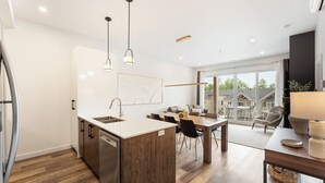 Una cocina moderna con una isla central, electrodomésticos de acero inoxidable e iluminación colgante.