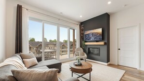 Una sala de estar moderna con un sofá, una mesa de centro y una chimenea.