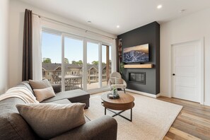Ein modernes Wohnzimmer mit einer Couch, einem Couchtisch und einem Kamin.