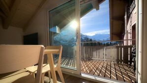 Un balcon avec un plancher en bois et une vue sur les montagnes.