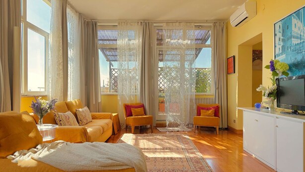 A bright living room with a sofa, chairs, and a TV. - Belsito Terrace, Rome Skyline (Roma)