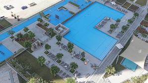 A large outdoor swimming pool with multiple sections, surrounded by lounge areas and pathways. - Luxury 2BR Burj Khalifa View Dubai Mall (Dubai)