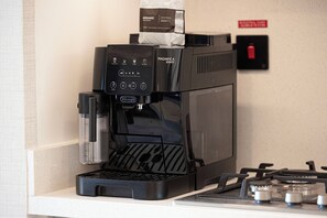 A coffee machine with a coffee bag on top, a control panel, and a gas stove below. - Luxury 2BR Burj Khalifa View Dubai Mall (Dubai)