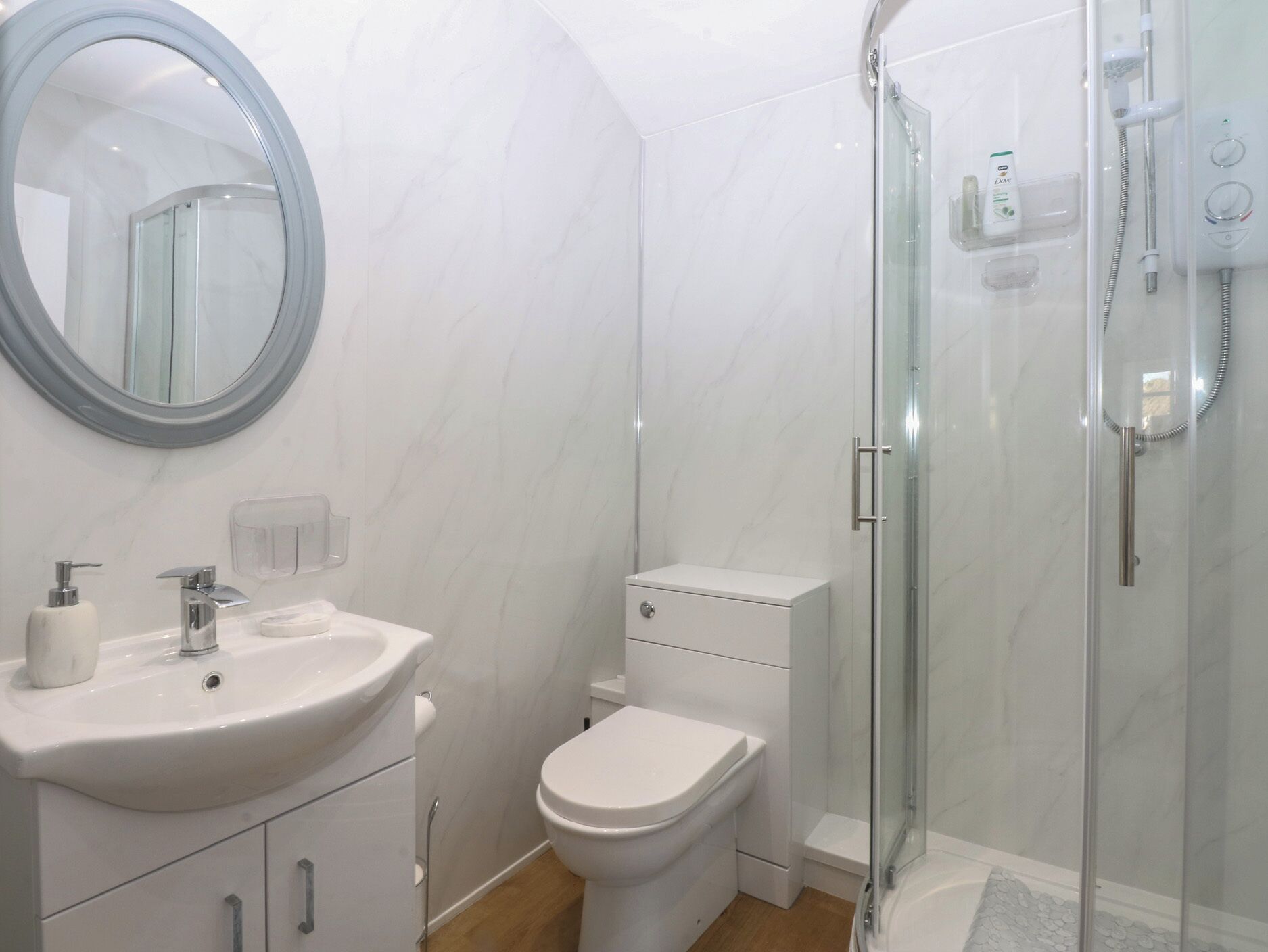 A bathroom with a sink, toilet, and glass-enclosed shower.
