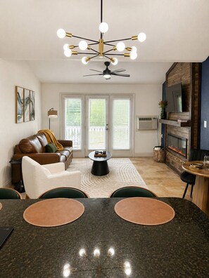A modern living room with a dining area, a ceiling fan, and a fireplace. - 2 Bedroom Condo ON Lake Hamilton! Sleeps 6! (Hot Springs)