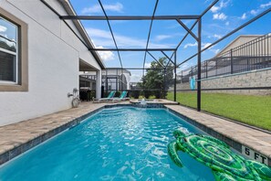 A swimming pool with a green inflatable toy, a covered area, and a brick border. - 5Bd Villa Private Pool & Spa At Solara Resort 1820 (Kissimmee)