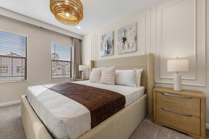 A bedroom with a bed, bedside tables, a lamp, and artwork on the wall. - 5Br & 5Ba Paradiso Grande - Walk To Seaworld 10507 (Orlando)