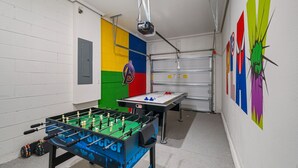 A room with a foosball table, a ping pong table, and a projector mounted on the ceiling. - 6Bd Villa W Spa, Star Wars Cinema & Gameroom 2088 (Kissimmee)