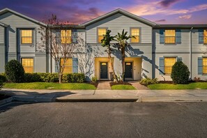 A two-story building with a symmetrical facade, multiple windows, and a central entrance. - Modern 5Br Downstairs Room, Pool & Lazy River 2402 (Kissimmee)