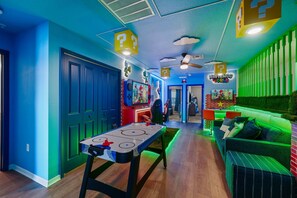 A room with a pool table, a sofa, and a Nintendo World sign. - Modern 5Br Nintendo Loft & Private Pool 16144 (Clermont)