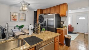 A modern kitchen with stainless steel appliances, wooden cabinets, and a granite countertop. - Family-Friendly 3BR Home Near DC (Arlington)