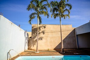 En swimmingpool med en palme i baggrunden.