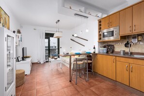 Eine moderne Küche mit Holzausbau, einer Edelstahl-Mikrowelle und einem Essbereich mit Tisch und Stühlen.