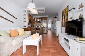 Ein modernes Apartment mit Wohnzimmer, Küche und Essbereich.