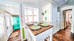 A compact kitchen with a wooden countertop, a teal cabinet, and a refrigerator. - 466 Marlin Dr. - Nice 2 Bedroom with Beach Chair Service Included! (Panama City Beach)