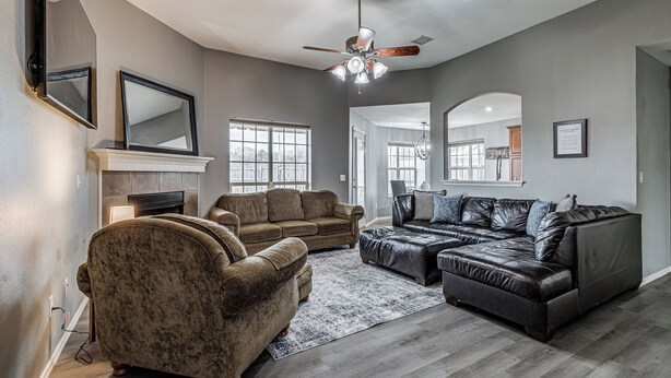 A spacious living room with a fireplace, two sofas, a large rug, and a ceiling fan. - 3-bedroom house in Coweta close to Broken Arrow (Coweta)