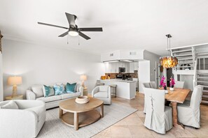 Un salon moderne avec un canapé, une table basse et un coin repas.