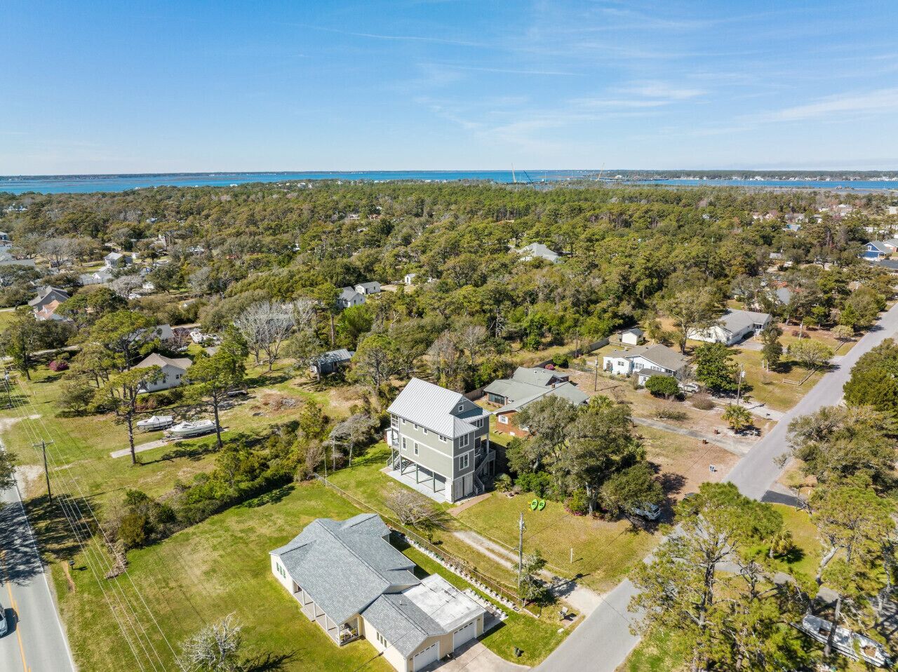 An aerial view of a residential area with houses, a large two-story building, and a road.