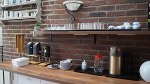 A kitchen counter with a coffee machine, a kettle, a toaster, and a coffee press. - Hotel am Weyerhof (Kerpen)