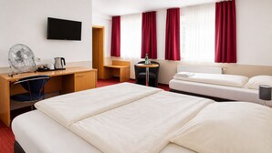 A hotel room with a bed, desk, chair, TV, and a window with curtains. - Hotel am Weyerhof (Kerpen)