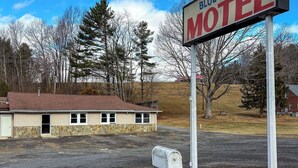 A motel sign, a building with a stone facade, and a mailbox. - Blue Ridge Mountain Inn (Meadows Of Dan)