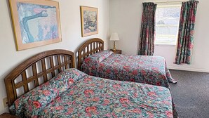 A room with two wooden beds, a nightstand, a lamp, and two framed pictures on the wall. - Blue Ridge Mountain Inn (Meadows Of Dan)