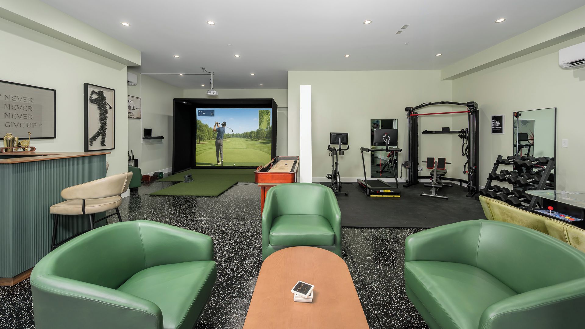 Une pièce moderne équipée d’un simulateur de golf, de matériel d’exercice et d’un espace bureau.