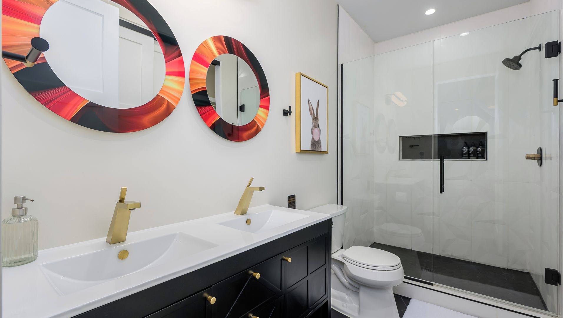 Modern dual bath with bold mirrors & gold accents.
