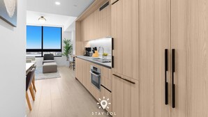 Una cocina moderna con armarios de madera, horno empotrado y un amplio ventanal con vistas.